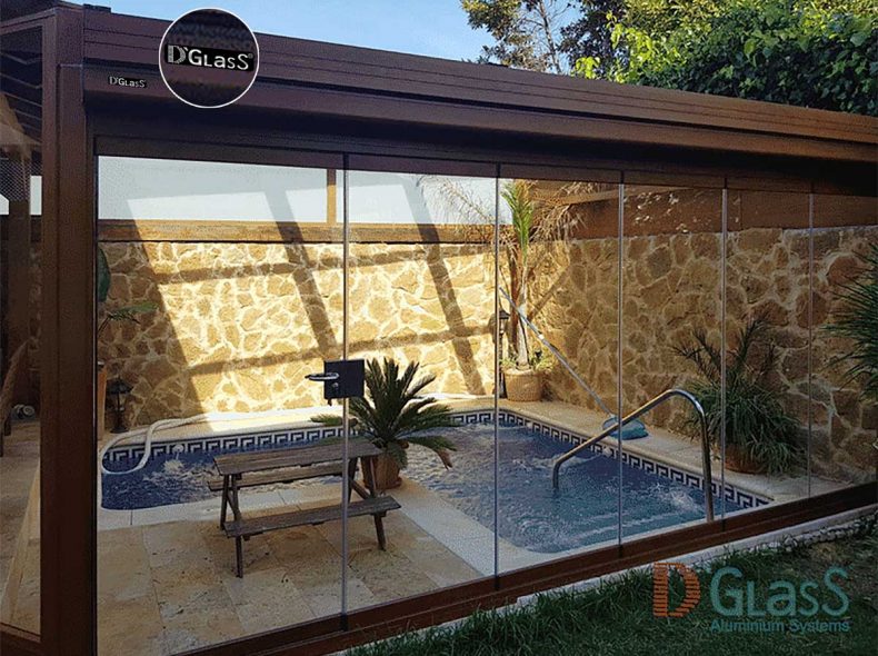 Techo móvil con cortinas de cristal en piscina